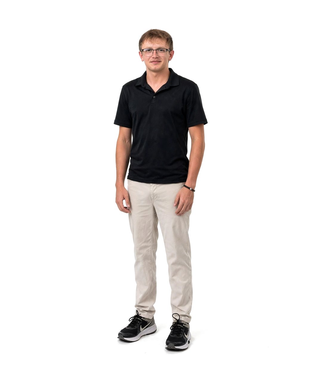 John standing, wearing a black polo, khaki pants and glasses